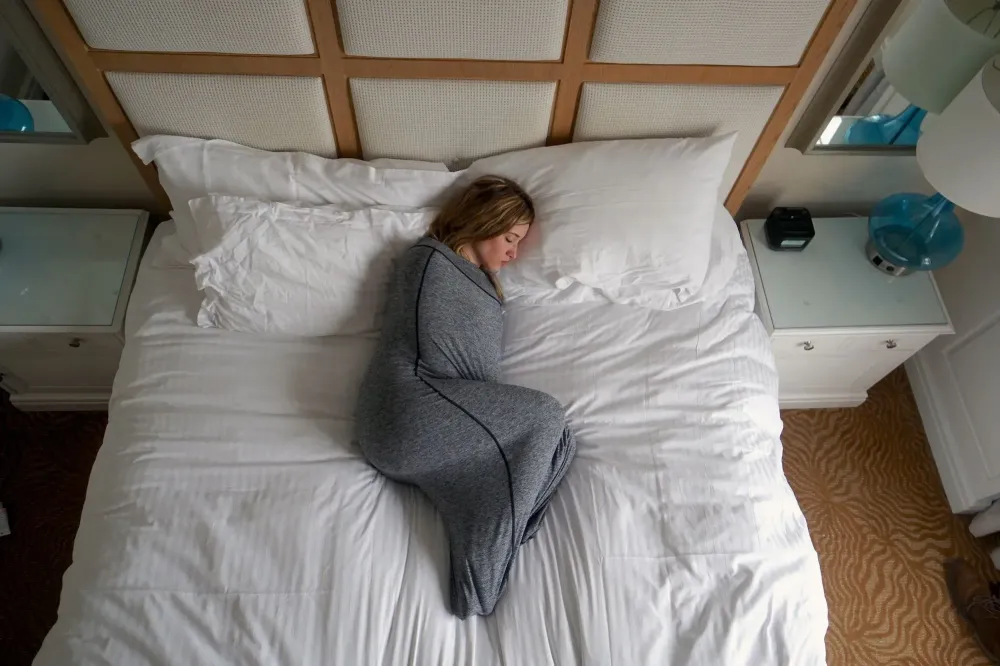 woman sleeping in bed with swaddle blanket